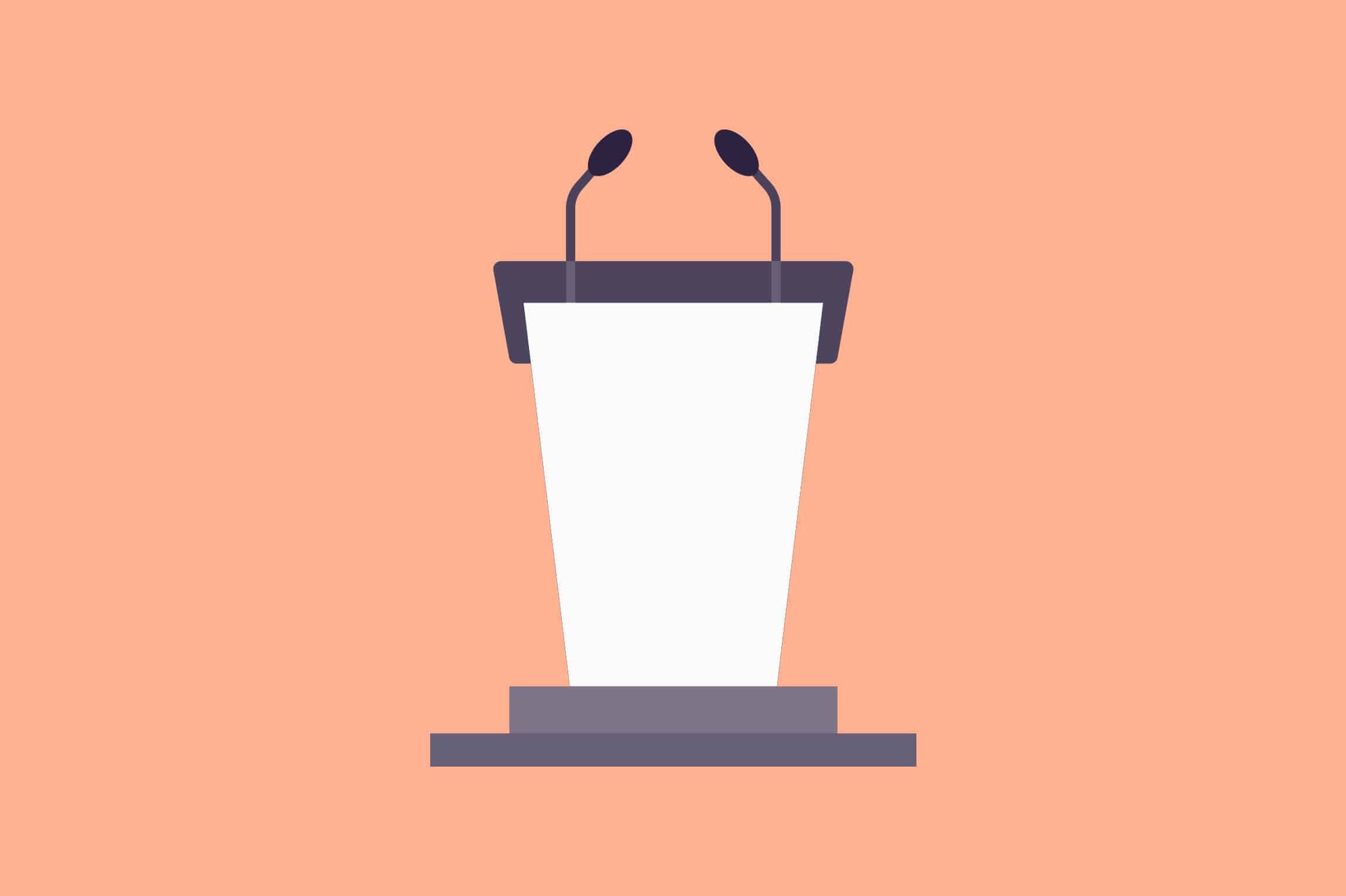 A peach-colored podium with a microphone in front of a stage